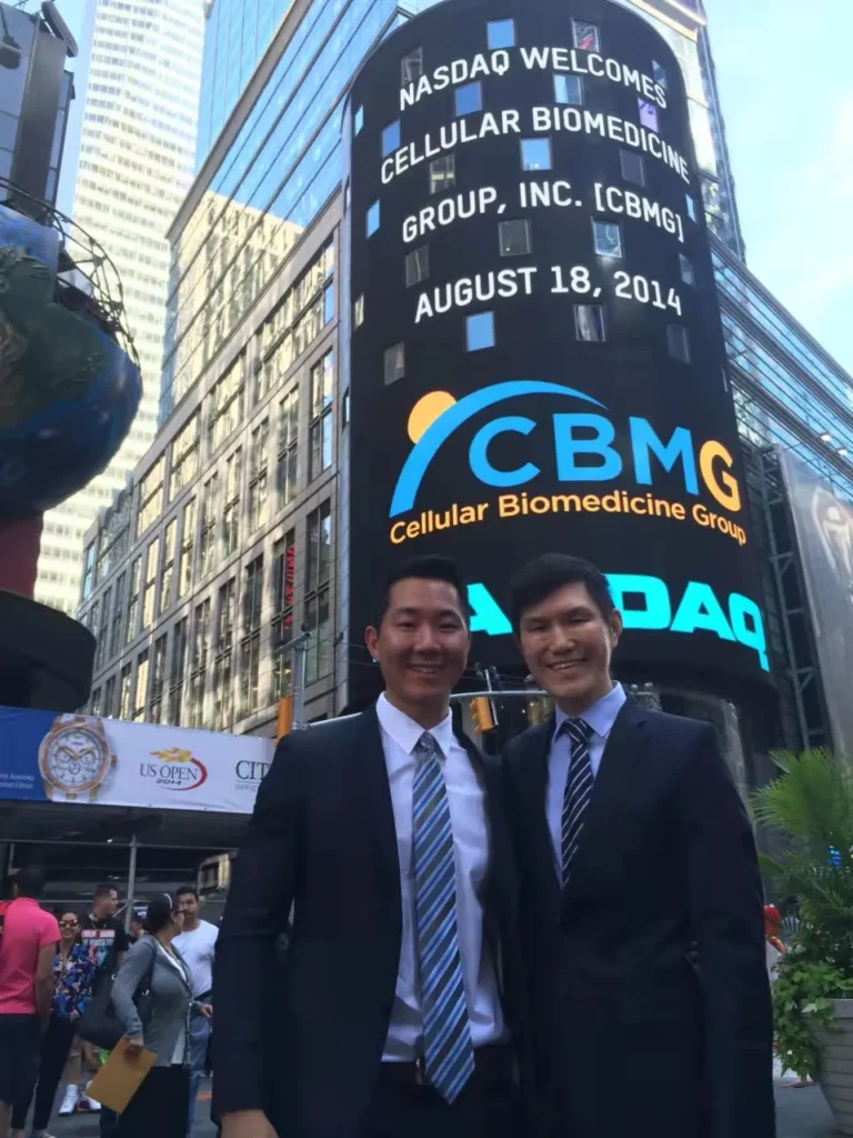2 men standing in front of a NASDAQ sign